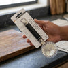 Eco-Friendly Kitchen Pizza Cutter held in hand, showcasing its durable design and packaging for efficient meal preparation.