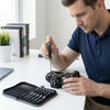 A person using a 7-Piece Precision Torx Screwdriver Set to repair a camera on a desk.