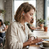 Wired In-Ear Headphones with 3.5mm Jack worn by a woman in a cafe while using a laptop.