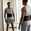 Man wearing an Adjustable Waist Protection Back Support Belt while looking in a mirror.