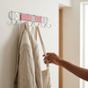 Chrome Plated 8-Hook Wall Mounted Rail holding a coat and bag on hooks in a modern entryway.