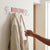 Chrome Plated 8-Hook Wall Mounted Rail holding a coat and bag on hooks in a modern entryway.