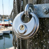 80mm Anti-Theft Stainless Steel Disc Lock securing a wooden post at a marina with boats in the background.