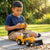 Boy playing with Kids Engineering Bulldozer Toy with Rolling Wheels in outdoor setting.