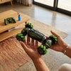6-Wheel Remote Control RC Stunt Car being held with a game controller in the background, showcasing its features.