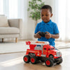 A child in a blue shirt playing with a remote-controlled Friction Powered Simulation Fire Truck Toy in a cozy room.