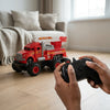 Child playing with Friction Powered Simulation Fire Truck Toy, controlling it with a remote while indoors.