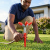 Man adjusting Garden Irrigation System with Adjustable 4-Arm Sprinkler on green lawn.