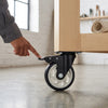 3-Inch Stainless Steel PU Swivel Caster used to move heavy furniture with ease in a workshop setting.