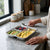SUS304 Stainless Steel 3 Compartment Food Tray with fruits and eggs on a kitchen counter.