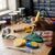 Person using a 40W Electric Soldering Iron and Welding Repair Kit on a circuit board with tools and supplies around.