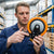Man inspecting a Heavy Duty Swivel Industrial Caster Wheel in a warehouse setting.