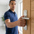 Person using Aluminum Plate Security Door Lever Handle on home entrance.