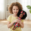 A child holds the 13-Inch Lifelike Black Girl Fashion Doll with curly hair and a floral dress, smiling in a bright room.