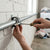 Installing a Heavy Duty Pipe Clamp with EPDM Rubber on a wall to secure pipes quietly and effectively.