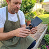 Man using a Carbon Steel Double Headed Garden Hoe-fork in a garden, showcasing its design and functionality.