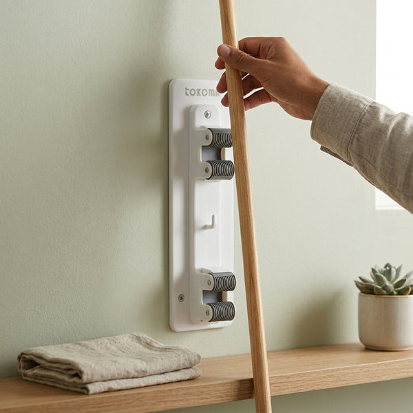 Image of a Wall Mounted Mop and Broom Holder Clip in use, organizing cleaning tools on a wall.