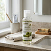 Natural Extract Moisturizing Olive Oil bottle on a bathroom countertop with towels and soap.