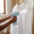 Person using 1000W Handheld Portable Garment Steamer to remove wrinkles from a white shirt.