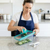 Woman using a Multi-functional Kitchen Vegetable Cutter Slicer to slice cucumbers on a kitchen countertop.