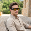 Man wearing HD Vision Wrap Around Night Driving Glasses outdoors, showcasing their sleek design and glare-reducing features.