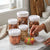 Easy Button Round Kitchen Storage Jar set with various snacks on a marble countertop.