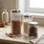 Ribbed Glass Airtight Food Storage Jar displayed with different contents including lentils, rice, and spices.