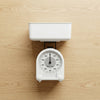 Mechanical Kitchen Scale 1kg with a white bowl for measuring ingredients on a wooden countertop.