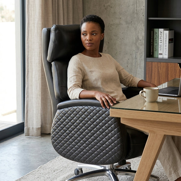 Executive Genuine Leather Reclining Office Chair in a modern workspace with a woman sitting comfortably at a desk.