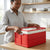 Woman using Foldable Plastic Storage Box with Lid in a modern kitchen to organize items.