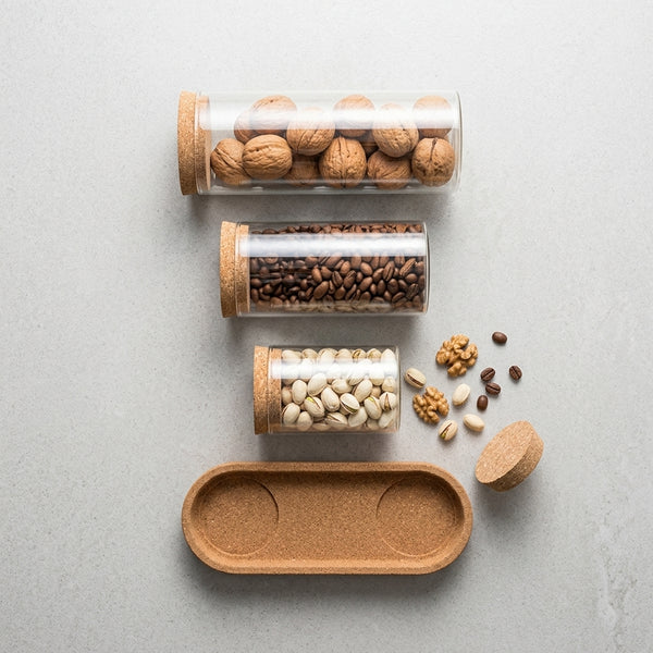 Stackable Borosilicate Glass Storage Jar with Bamboo Lid filled with various nuts and coffee on a countertop.