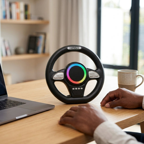 Steering Wheel Bluetooth Speaker placed on a table next to a laptop and coffee cup, showcasing hands-free audio functionality.
