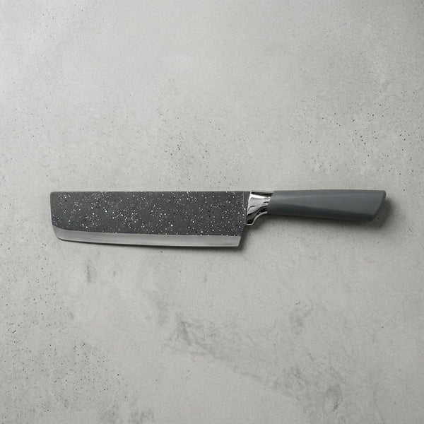 Velvet-Touch Pastel Precision Knife on a textured gray surface, showcasing its sleek design and fine cutting edge.