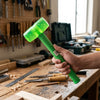 A person holding an Industrial Copper Soft Face Machinist Hammer in a workshop setting.