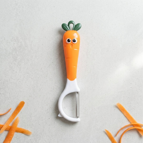 Cute Cartoon Carrot Vegetable Y-Peeler on a countertop with carrot peels.