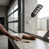 500W Solar Power System Street Light Lamp installed indoors with a hand reaching for keys on a table.