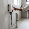 User adjusting the control panel of a 2HP Solar Deep Well Borehole Pump in a modern setting.
