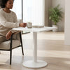 Modern Marble-Style Side Table beside a woman holding a cup in a bright living room.