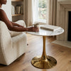 High-End Modern Nordic Imitation Marble Coffee Table beside cozy armchair with coffee and book.