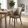 Taupe PU Leather Dining Chair with Gold-Tipped Legs in a modern dining space with wooden table and greenery.