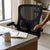 Adjustable Ergonomic Full Mesh Office Chair next to a desk, showcasing its breathable design and comfort features.