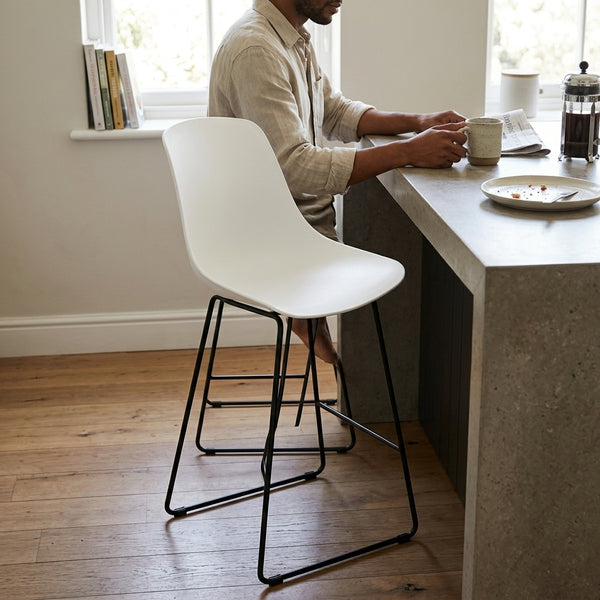 Commercial Bar Stool with PP Seat at a kitchen counter, modern and sleek design for commercial or home use.