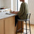 Houndstooth Bar Stool with Black Metal Frame and Footrest in a modern kitchen setting with a woman sitting