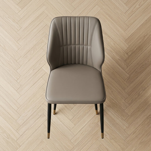 Modern Faux Leather Dining Chair with Channel-Tufted Back on herringbone floor