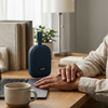 V82 Portable Wireless Speaker on a desk next to a coffee cup, great for convenient audio enjoyment.