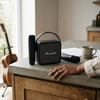 Mini Karaoke Amplifier with Microphones on a kitchen counter, featuring two microphones and a coffee mug.