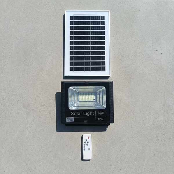 40W Solar Floodlight with solar panel and remote control on a concrete surface