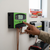 Person adjusting the 10A PWM Solar Charge Controller mounted on the wall for solar panel battery management.