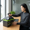 Woman using 720Wh Portable Power Station AC Output USB-C Solar on desk with laptop.