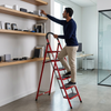 A person using a 6-Step Household Folding Ladder to reach items on a high shelf in an office setting. 7-Step Household Folding Ladder